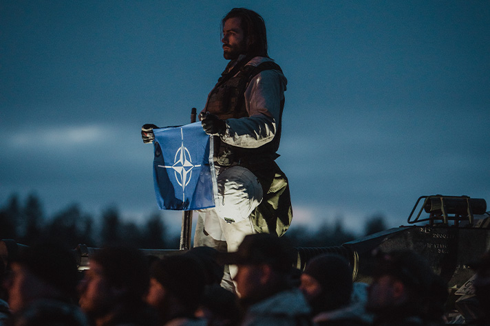 Soldier holding the NATO flag.