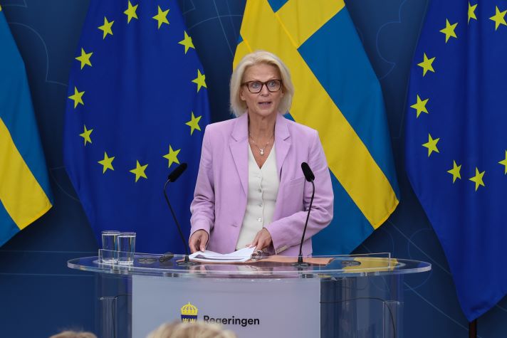 Elisabeth Svantesson, Minister for Finance in front of a Swedish flag and EU-flags