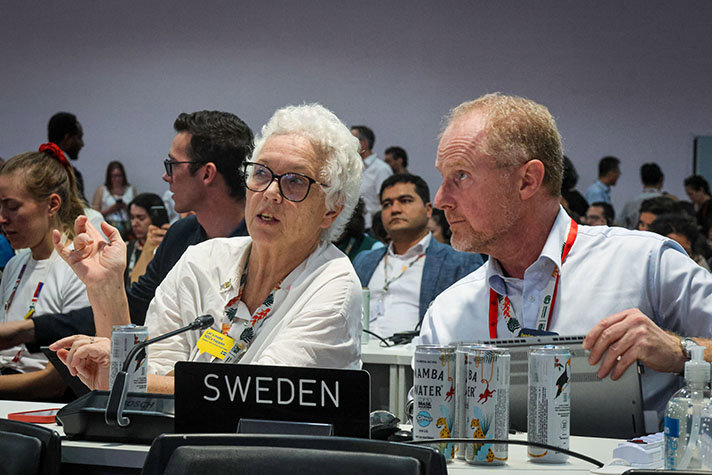 Two persons sitting in the conference room.