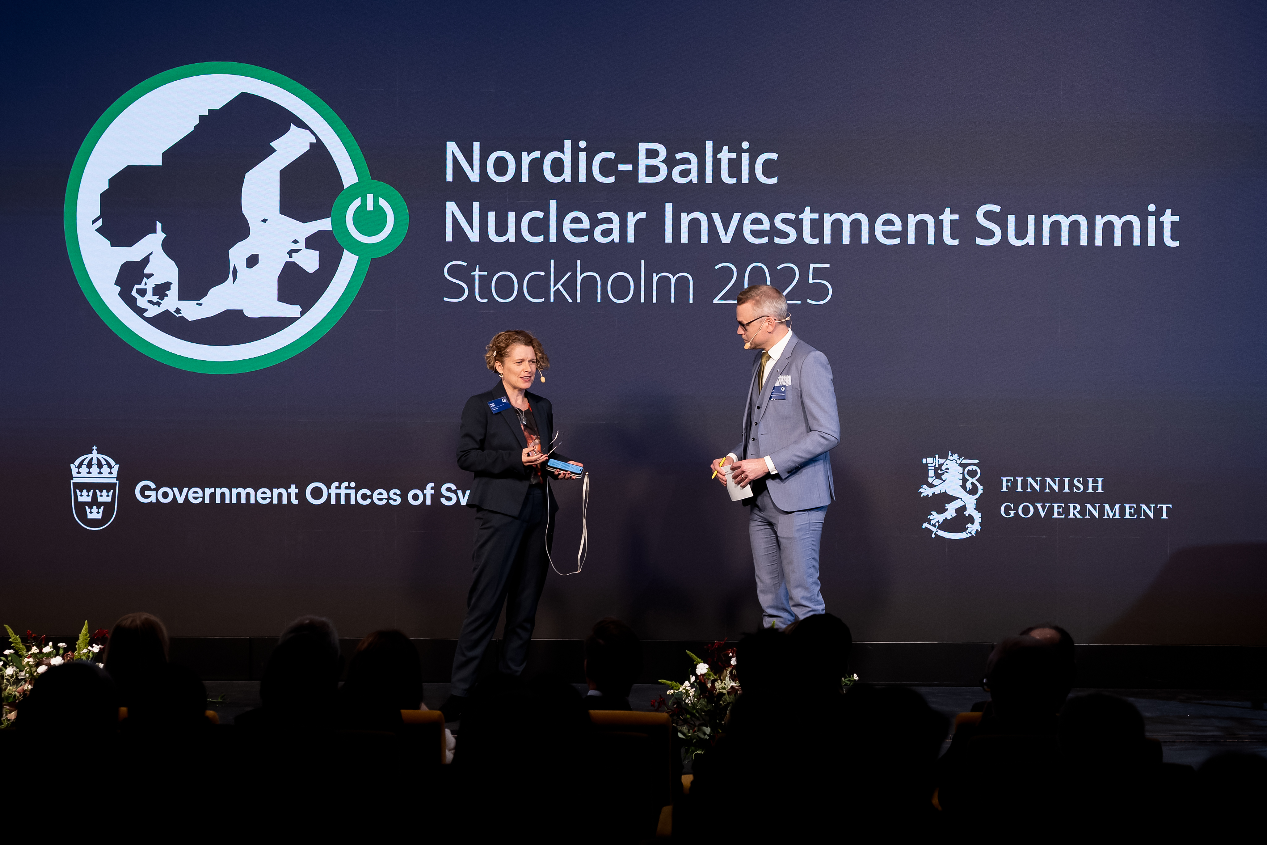 The moderator in a discussion with one of the speakers on stage