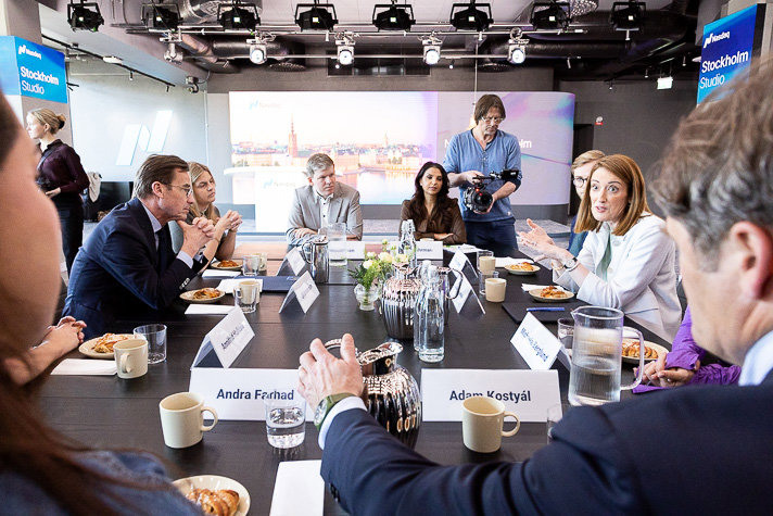 Ulf Kristersson and Roberta Metsola are sitting with several others around a table, engaged in discussion.