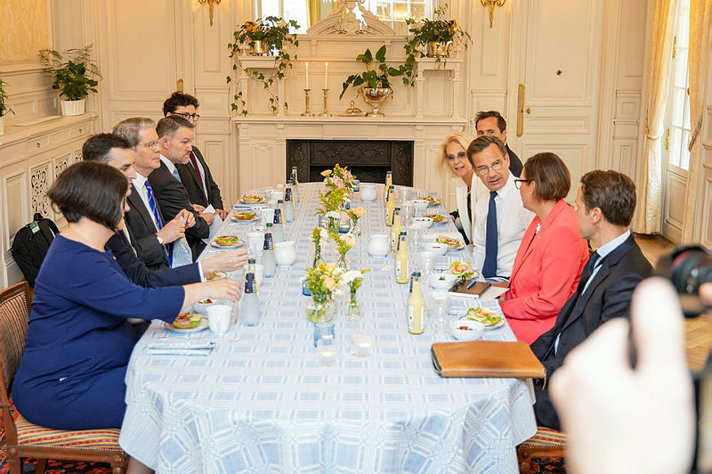Swedish representatives and american representatives seated around a table.