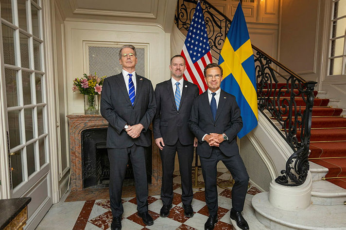 Prime Minister Ulf Kristersson together with U.S. Secretary of the Treasury Scott Bessent and U.S. Trade Representative (USTR) Jamieson Greer at the Sager House, in front of the American and Swedish flags.