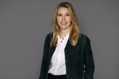 Woman wearing a black jacket and a white blouse.
