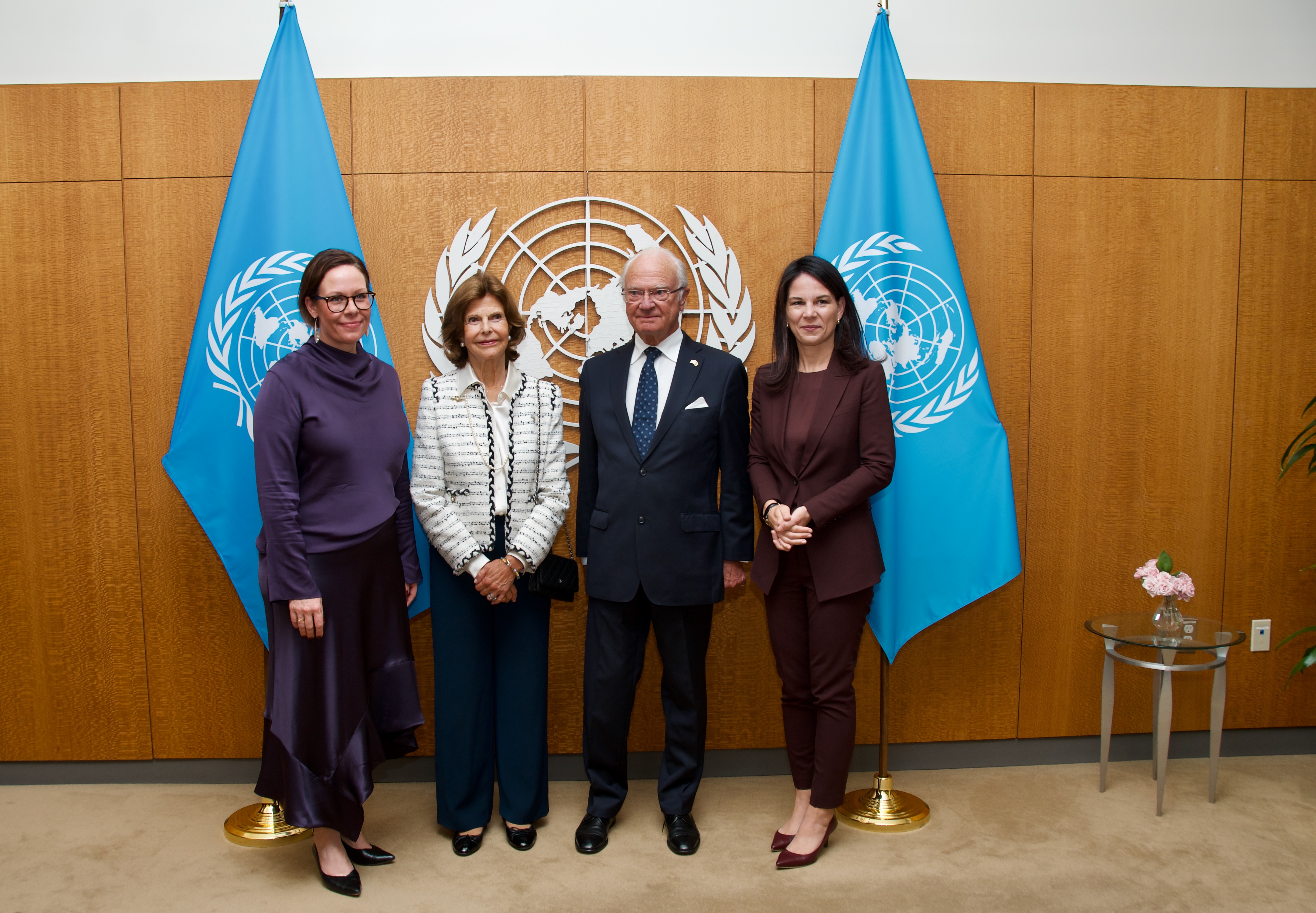 Minister for Foreign Affairs Maria Malmer Stenergard, His Majesty The King and Her Majesty The Queen and President of the United Nations General Assembly Annalena Baerbock in front of the UN symbol and flags..