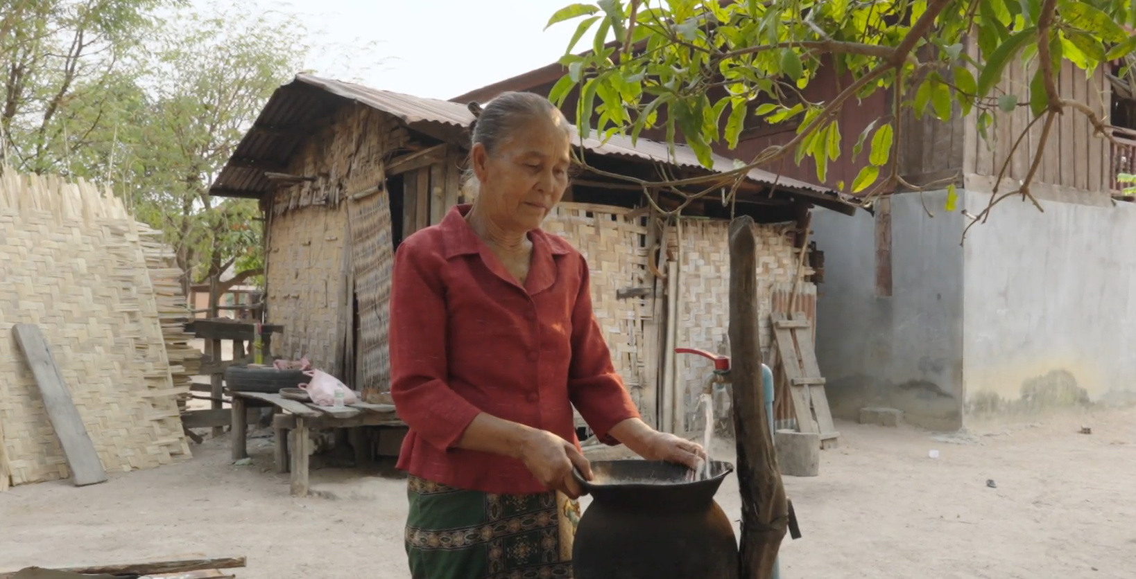 Woman filling up container with water.