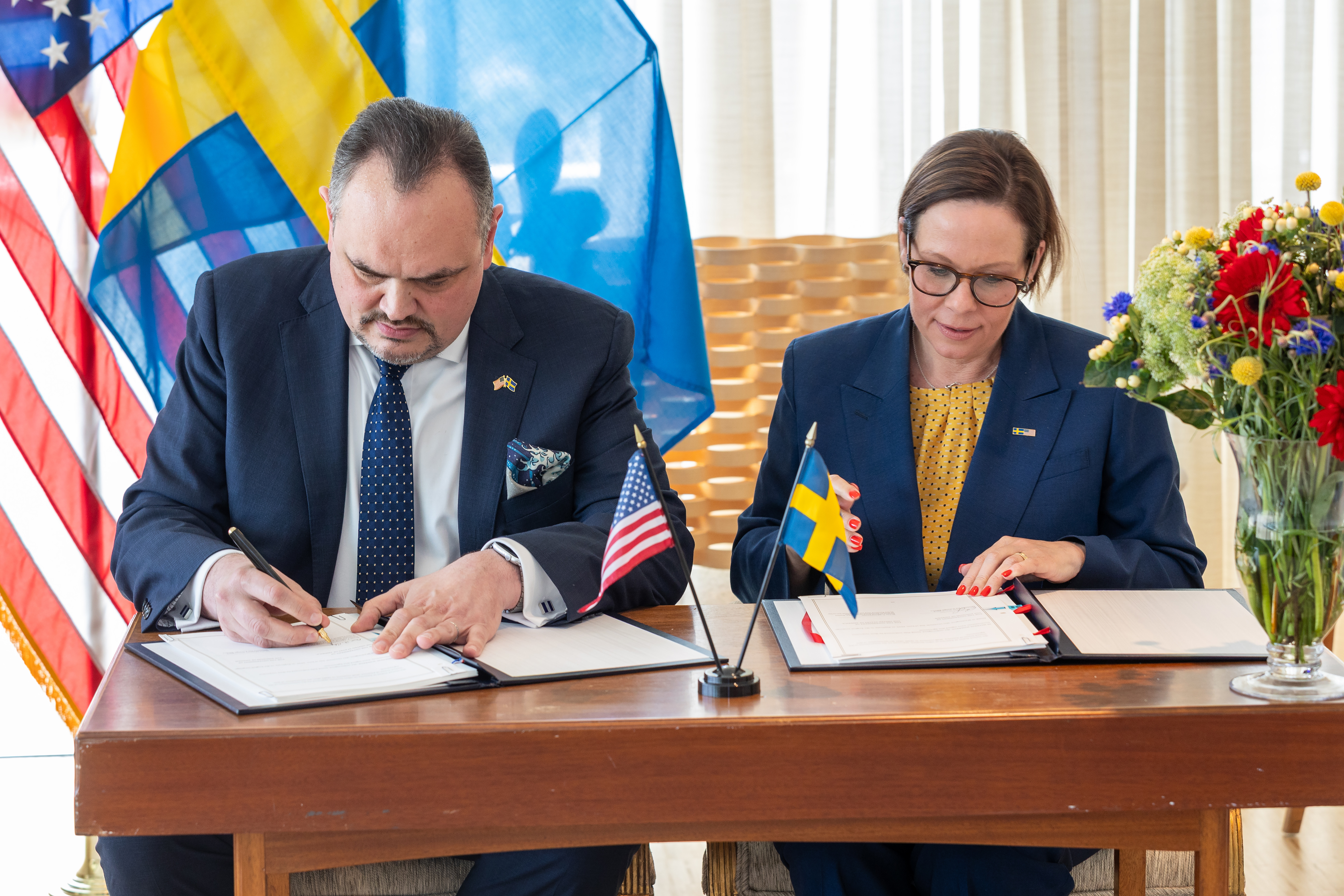 Maria Malmer Stenergard sits at a table and signs an agreement with the US.