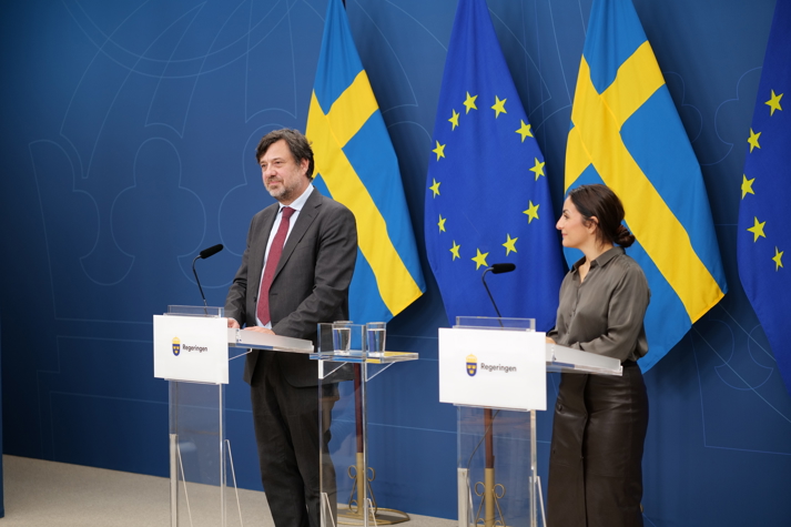 Two persons standing in front of an audience